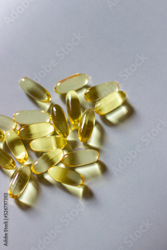 Medical yellow pills with vitamins are on a gray background
