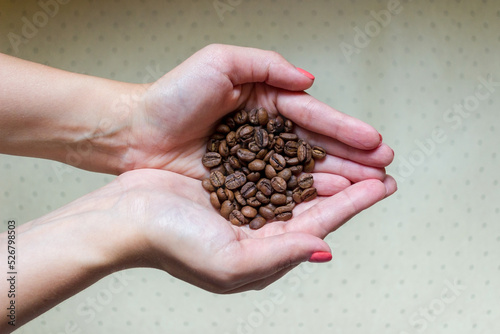 Hands are folded together and holding coffee beans © leriostereo