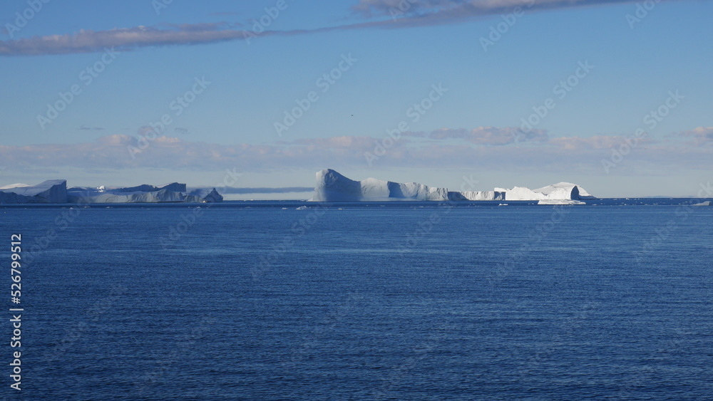 Panoramic view of icebergs at calm sea during cruise in Greenland