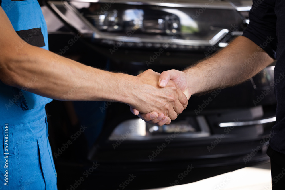 Automotive mechanic repairman handshake with client in garage. Vehicle service manager working in mechanics workshop. Success after check and maintenance car engine for customer. Car repair