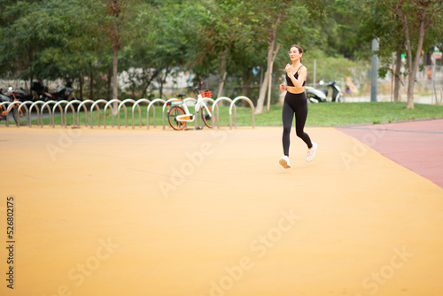 Healthy young woman in sportswear on morning run in the park