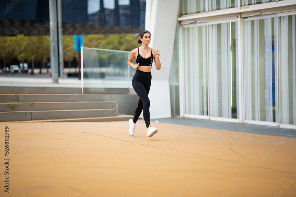Fit young woman in sportswear on morning run Fit young woman in sportswear on morning run