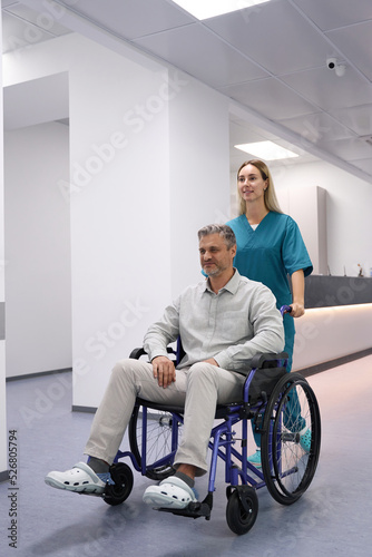 Doctor carries a patient in a wheelchair