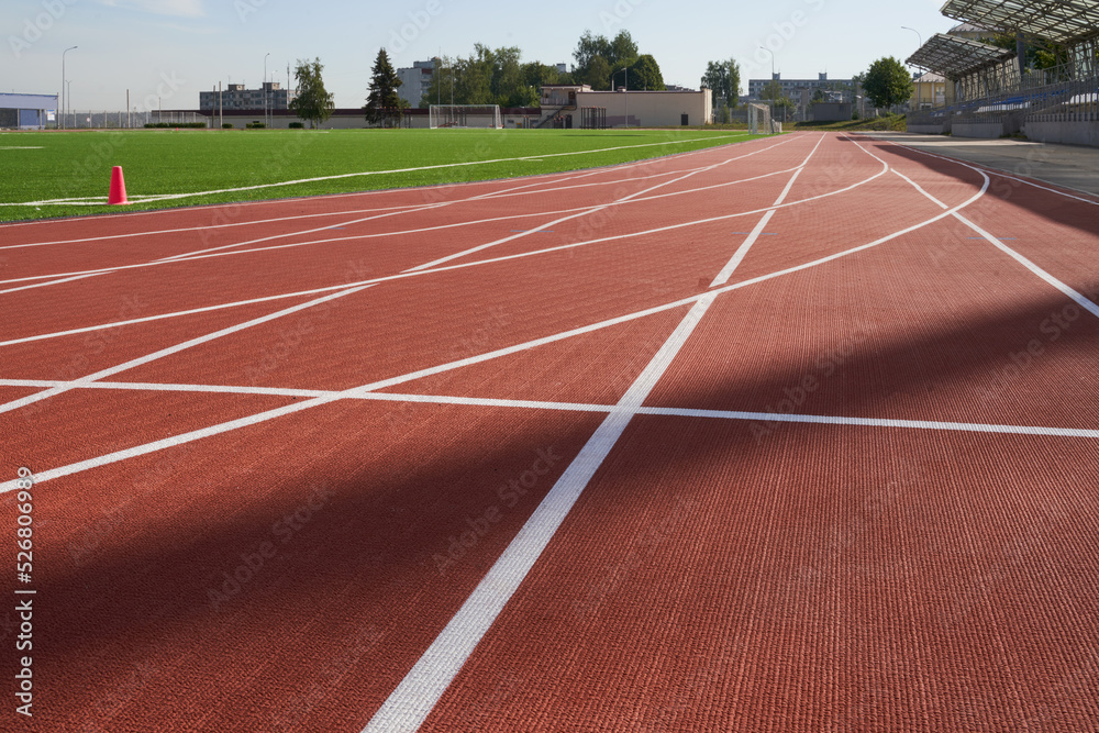 Fototapeta premium Running track. Red treadmill at the stadium with white lines.