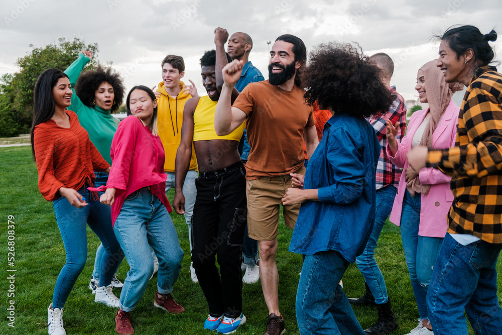 Fototapeta premium Group of young people of multi-ethnic origin dancing together outdoors