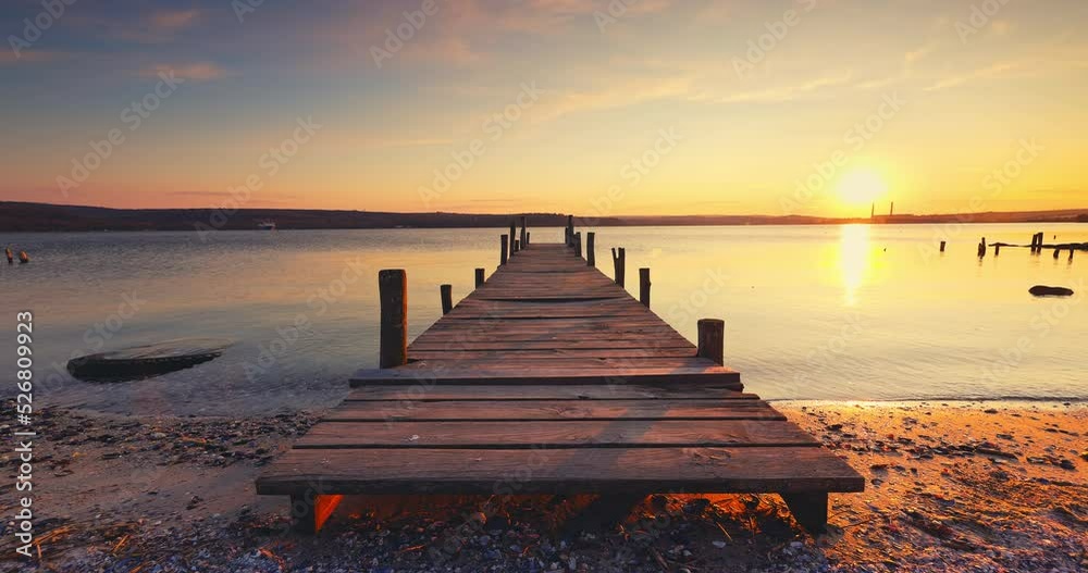 Old fishing jetty, wooden pier and scenic sunset over sea lake, 4K video of nature landscape
