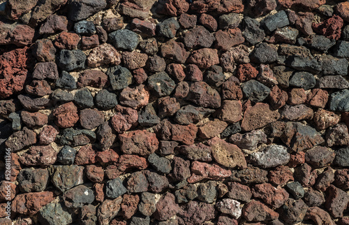 Wall built of lava remains or igneous rocks. Close-up. photo