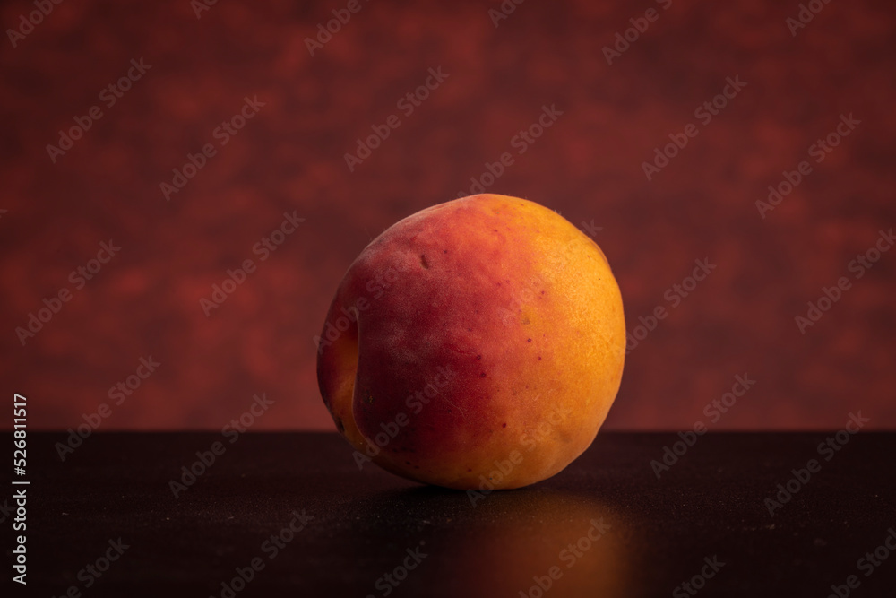 Fresh apricots on black table with red background