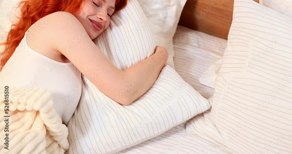Happy woman sleeping in bed in morning at home hugging pillow. Happy woman sleeping in bed in morning at home hugging pillow.