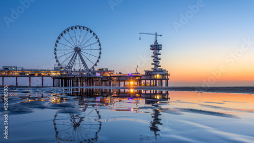 Beautiful sunset at the beach of Scheveningen in the Netherlands with the famous Pier in the background