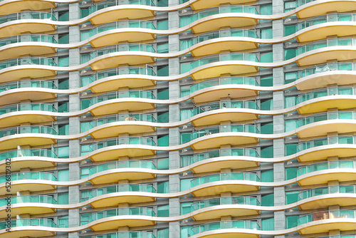 Glass green balconies windows of facade modern city building. Facade of building texture closeup