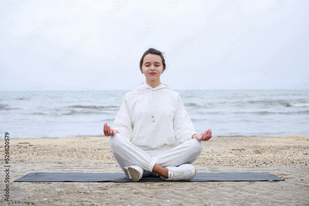 Portrait of young lady doing her meditation at the beach