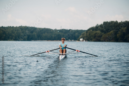 Sportsman single scull man rower rowing technique on boat. Paddle oar splash movement