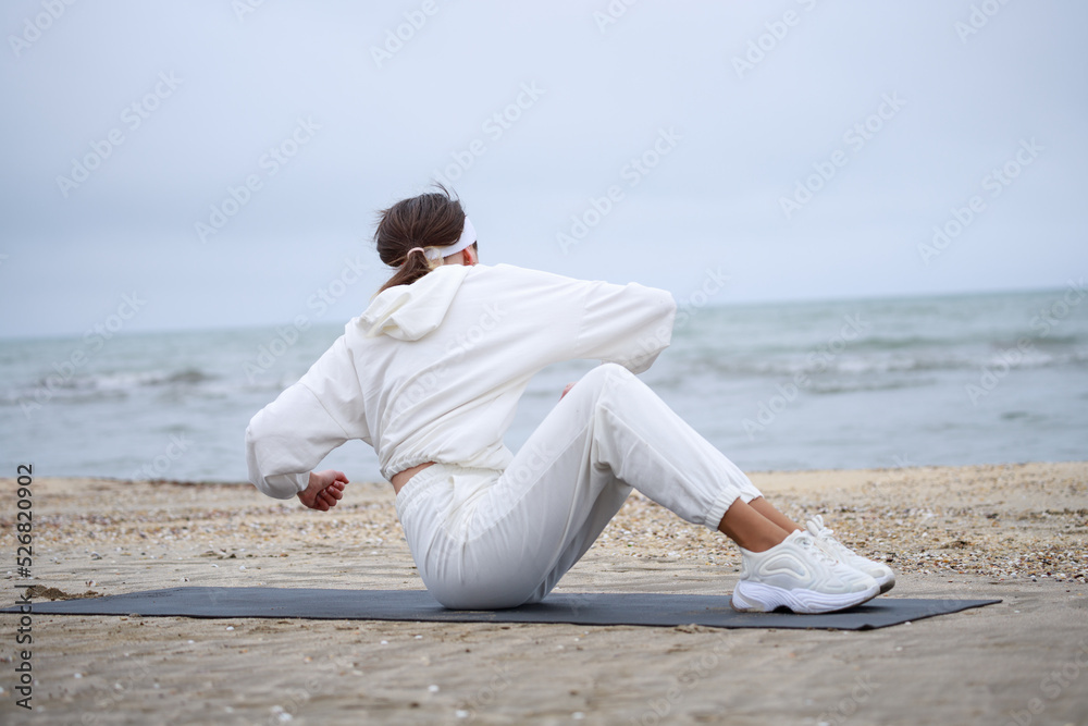 The young beautiful girl laying on the yoga mat and shaking her body The young beautiful girl laying on the yoga mat and shaking her body