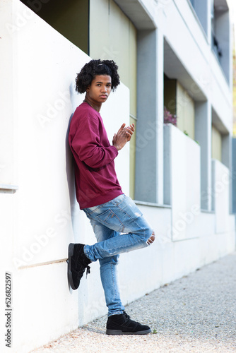 Portrait of black man leaning outdoors on wall