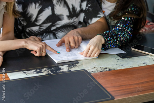 Photo of three persons hand on the notebook