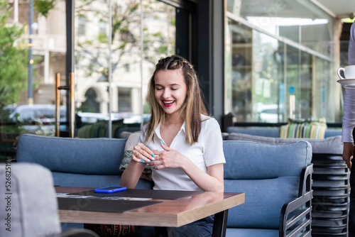 Free Download Beautiful cute blonde sitting at the restaurant and laughing - GFXLoad