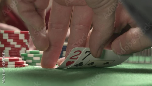 Looking bad poker cards. On the background sexy woman player checking her hand