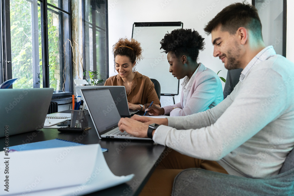 Casually dressed young businesspeople at the office. Discussing ideas for a new startup project.	