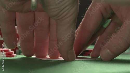 Gamer playing poker, checking his cards, having a winning combination ace and king. On the background are chips and alcohol 
