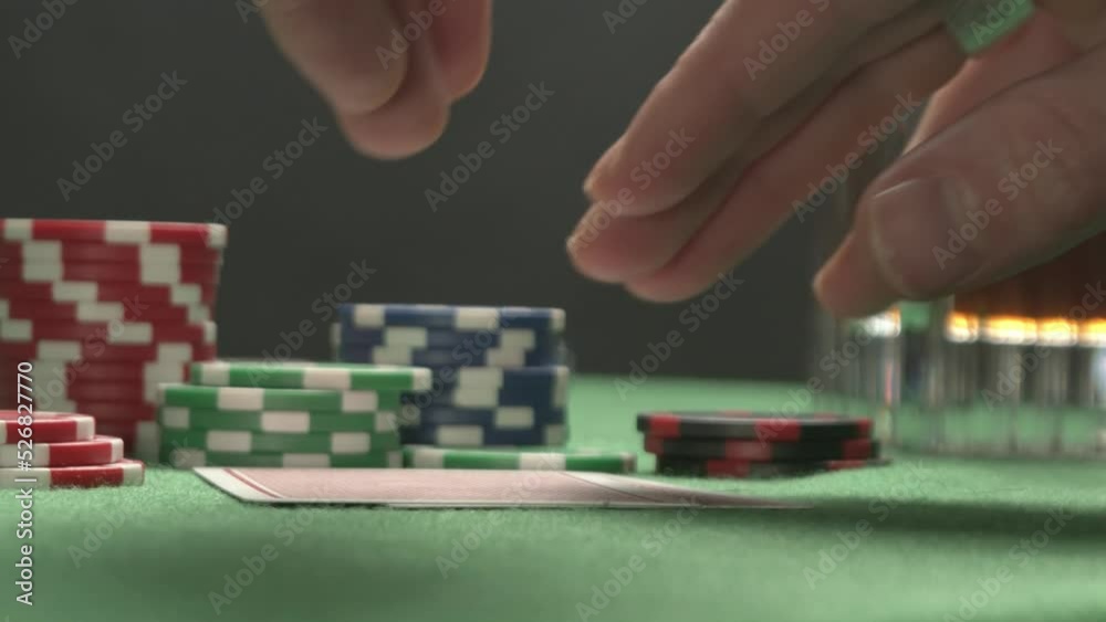 Poker player with a tattoo checking his hand, having a pair of jacks. Poker player with a tattoo checking his hand, having a pair of jacks.