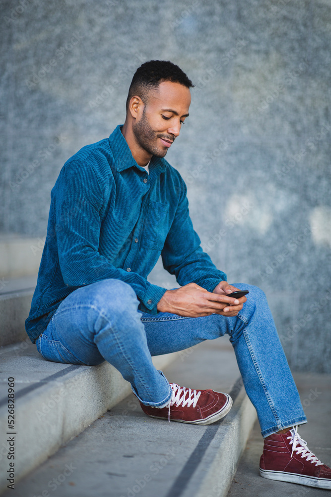 Man using mobile phone while sitting on stairs outdoors