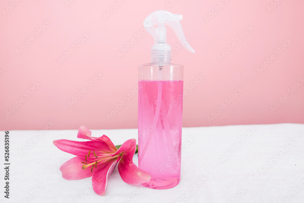 Spray bottle with pink liquid and rose flower with copy space. Spray bottle with pink liquid and rose flower with copy space.