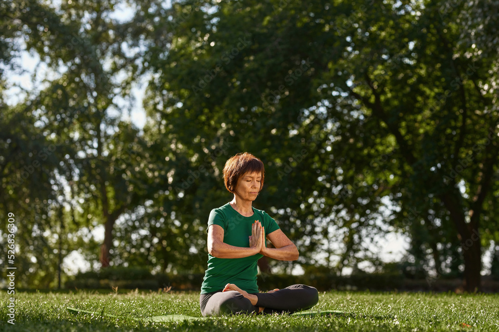 Caucasian mature woman meditating in lotus pose Caucasian mature woman meditating in lotus pose