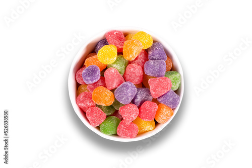 Colorful candy in bowl isolated on white background. Top view
