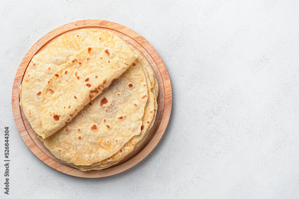 Traditional Indian chapati cakes on a wooden board on a gray background. Top view, copy space. Healthy, fiber-rich food Traditional Indian chapati cakes on a wooden board on a gray background. Top view, copy space. Healthy, fiber-rich food