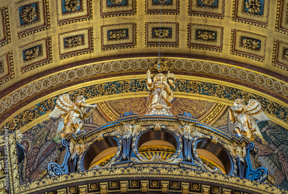 London, England, UK - July 6, 2022: St. Paul's Cathedral. Detail featuring golden statues of angels adoring preaching saint on bow supporting choir ceiling.