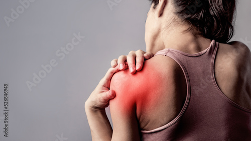 Young strong sporty woman doing the hands the  to relax the tension shoulder and blades in sport wear with red highlighted on empty copy space. Sports exercising injury.  concept of medicine photo