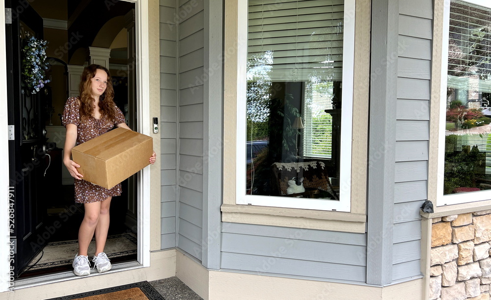 Vertical video where the girls brought the delivery She happily runs out, takes the box, looks around and goes back home She is wearing sneakers and a brown short trendy dress. Vertical video where the girls brought the delivery She happily runs out, takes the box, looks around and goes back home She is wearing sneakers and a brown short trendy dress.