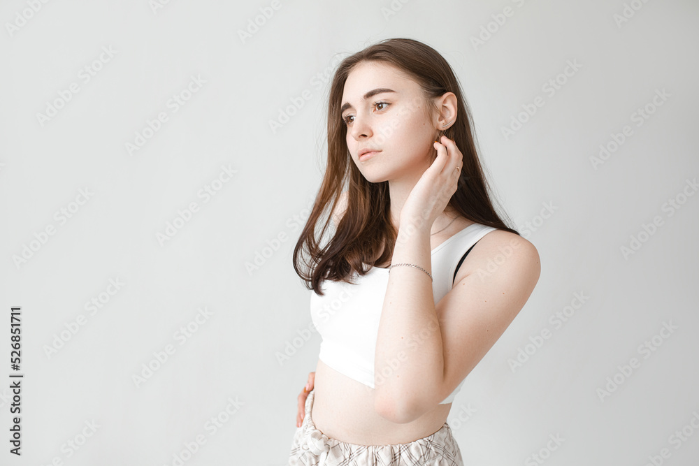 Young beautiful girl with clean skin. Women without wrinkles on the face close-up on a gray background Young beautiful girl with clean skin. Women without wrinkles on the face close-up on a gray background