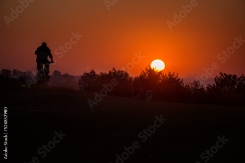 silhouette bike on sunset and bicycle background © pavlobaliukh