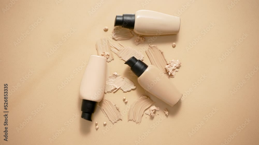 Bottles of makeup foundation and samples on beige background Bottles of makeup foundation and samples on beige background