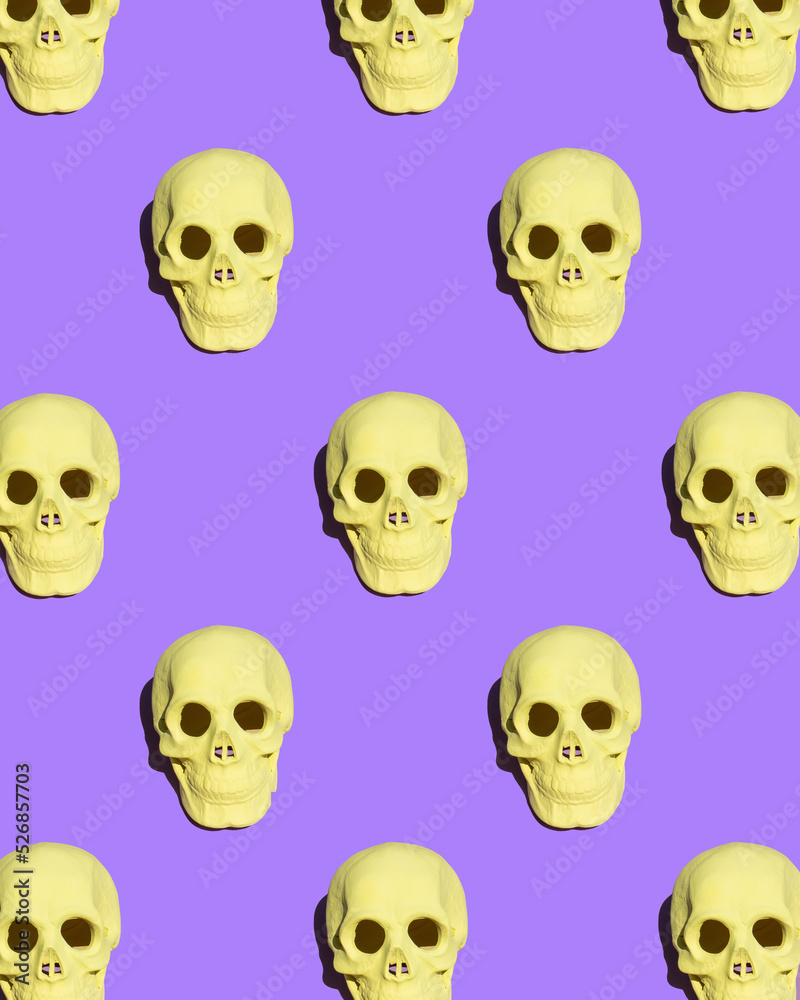 Colorful Halloween concept. Skull pattern on bold purple background. Creative holiday composition.