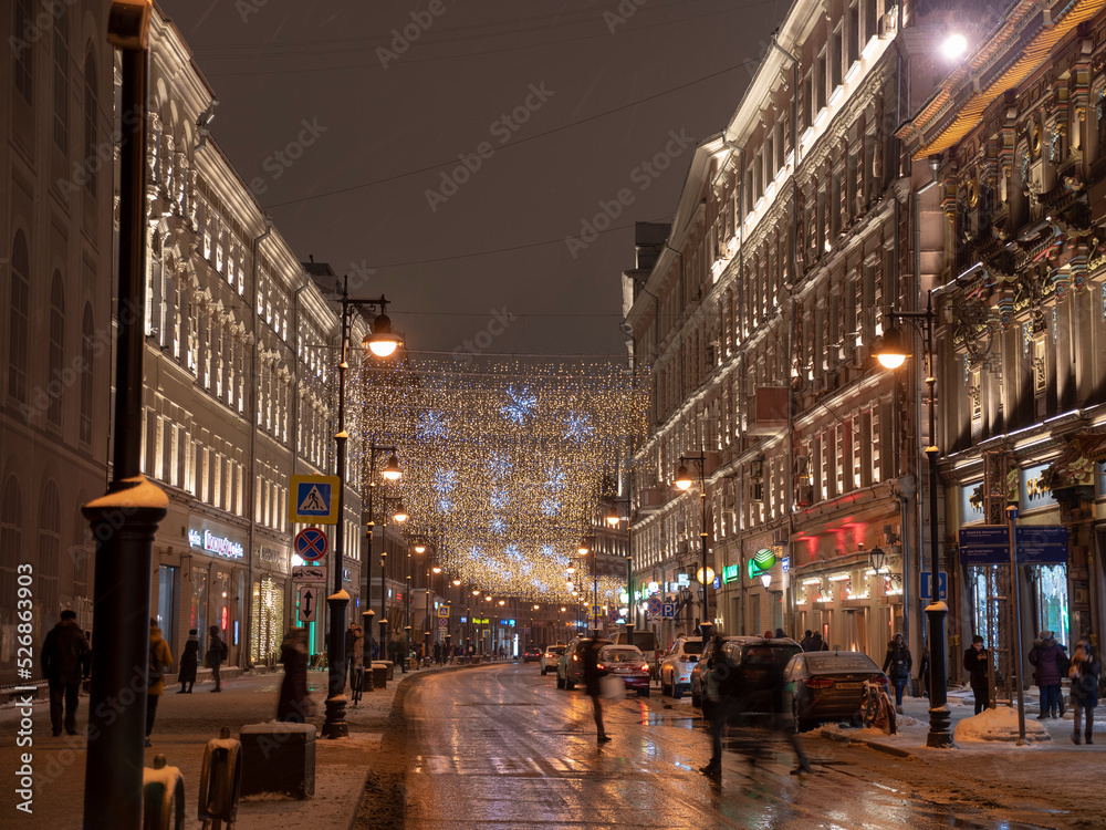 Golden rain of Christmas decorations hanging from the sky, on Nikolskaya street in Moscow