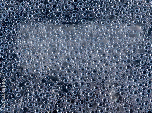 Water droplets gray background on window pane