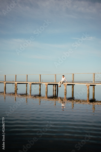 A lonely man sitting on the dock early in the morning