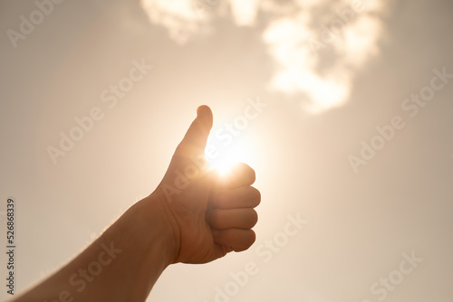 Hand gesture thumbs up on sunny sky. People yes, ok, positive symbol
