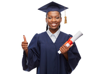 education, graduation and people concept - happy graduate student woman in mortarboard and bachelor gown with diploma showing thumbs up over white background