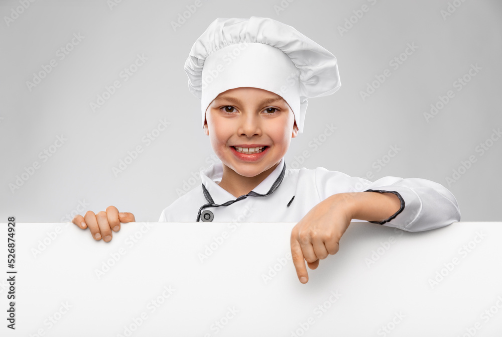 cooking, culinary and profession concept - happy smiling little boy in chef's toque and jacket with white board over grey background