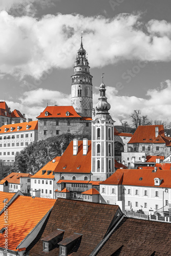 Black and white photo of church and castle in Cesky Krumlov, Czech republic. Color Splash Effect with red roofs of buildings. Vertically. 