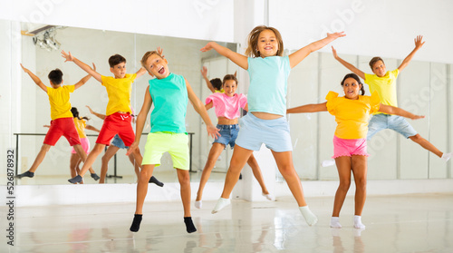 Portrait of satisfied boys and girls jumping having fun after dance class