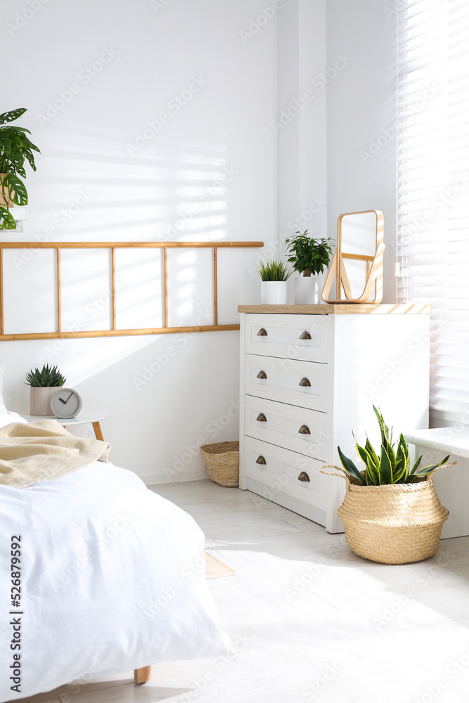 Fototapeta premium White chest of drawers in beautiful bedroom. Interior design