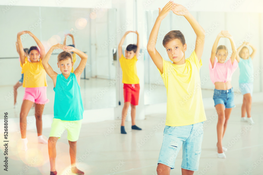 Fototapeta premium Group of kids training dance moves together in studio.