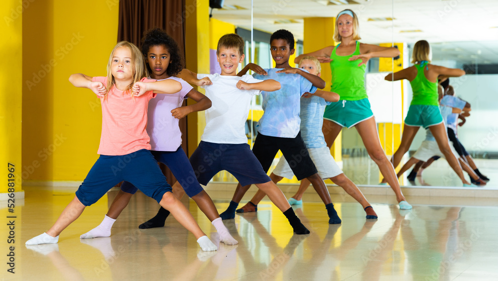 Cheerful little children studying modern style dance in class. High quality photo