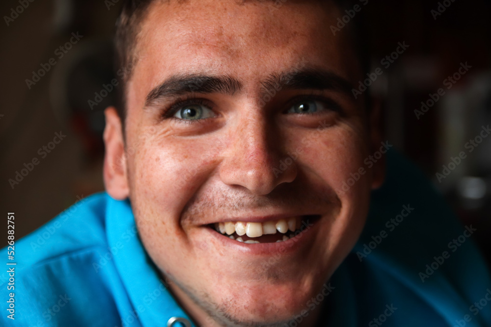 Fototapeta premium Defocus 20s smiling man. Closeup portrait of a happy young man smiling on blurred background. Face young man with funny kind eyes and smile. Out of focus