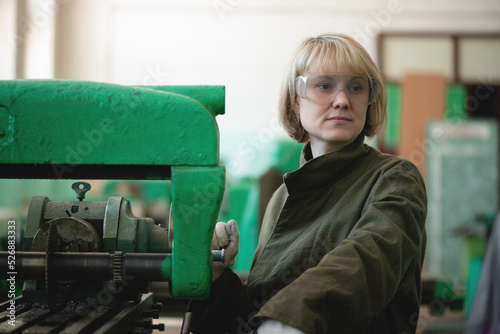 Woman in protective glasses in a workshop.